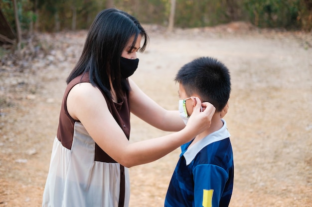 La madre indossa una maschera per proteggere suo figlio dal virus covid-19.