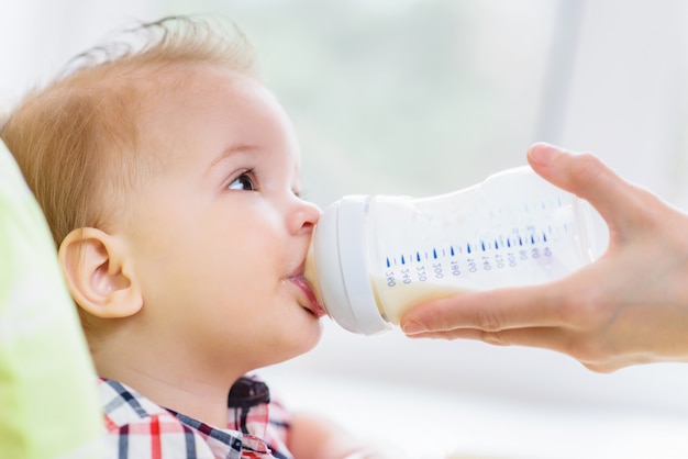 La madre nutre il bambino da una bottiglia di latte