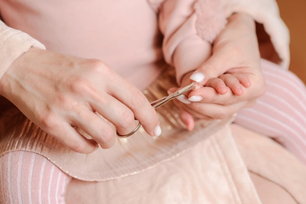 La madre premurosa taglia le unghie al piccolo bambino