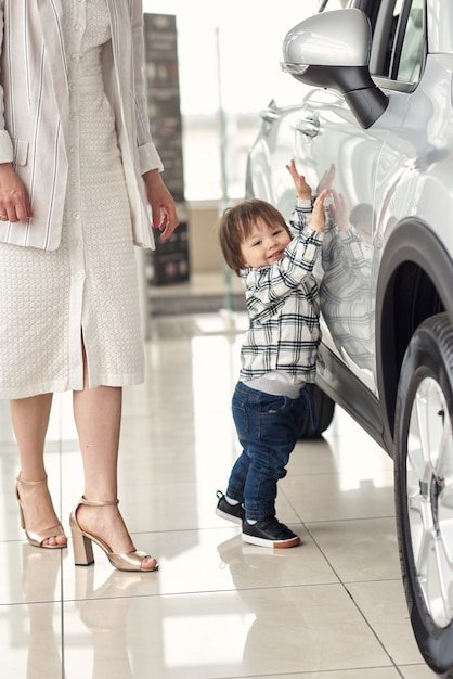 La madre sceglie un'auto in cui sarà conveniente trasportare il suo piccolo figlio.