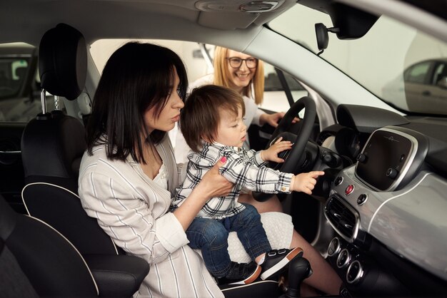 La madre sceglie un'auto in cui sarà conveniente trasportare il suo piccolo figlio.