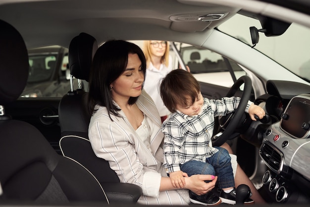 La madre sceglie un'auto in cui sarà conveniente trasportare il suo piccolo figlio.