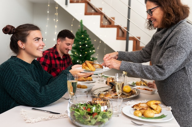 La madre serve alla figlia un pezzo di pollo arrosto cena in famiglia di Natale Vacanze