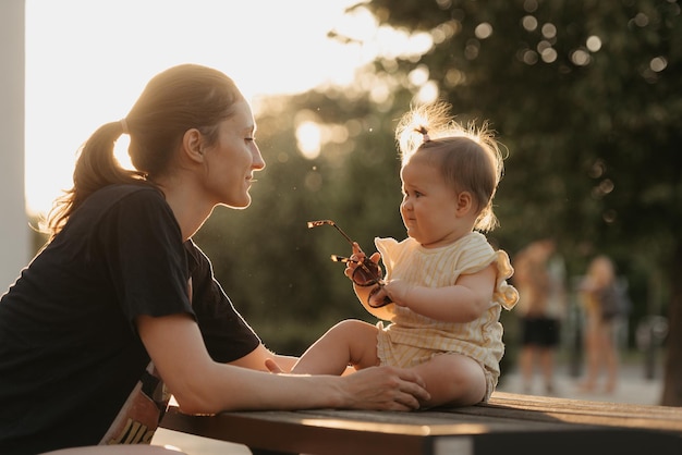 La madre sta trattenendo la sua giovane figlia dalla caduta al tramonto