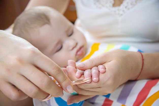 La madre taglia le unghie del bambino Messa a fuoco selettiva