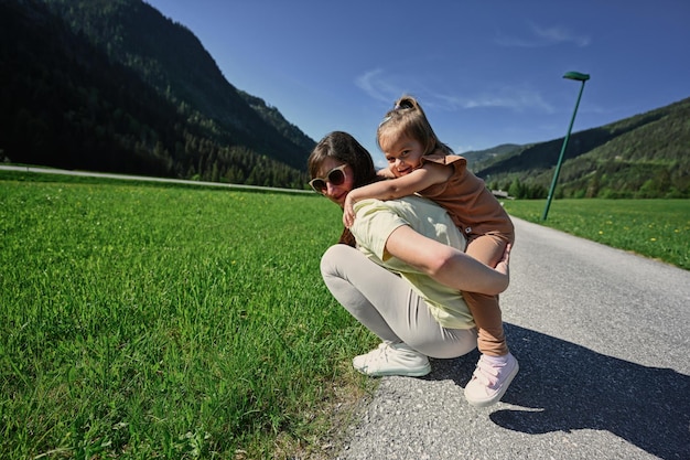 La madre tiene un bambino sulle spalle nel prato alpino a Untertauern Austria