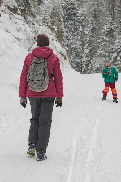 La madre va incontro a suo figlio su una strada invernale innevata nella foresta