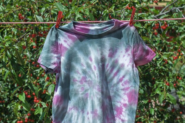 La maglietta tie dye rosa e grigia si asciuga dopo la verniciatura