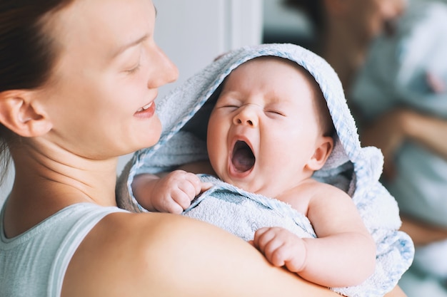 La mamma abbraccia il suo bambino più carino dopo il bagno con un asciugamano sulla testa Vita familiare Madre e bambino