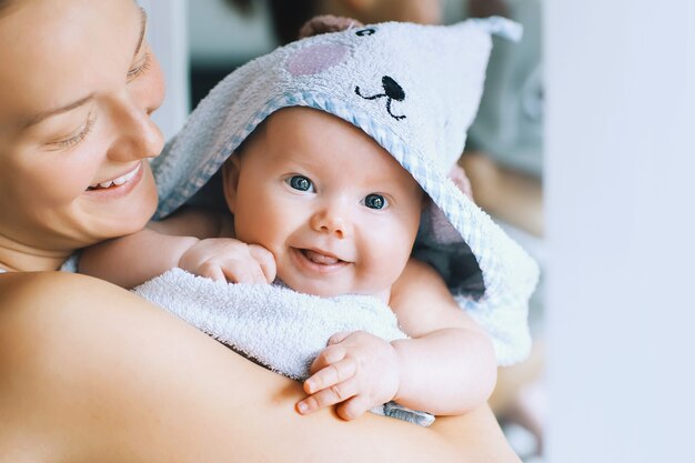 La mamma abbraccia il suo bambino più carino dopo il bagno con un asciugamano sulla testa Vita familiare Madre e bambino