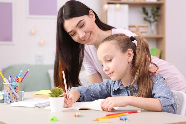 La mamma aiuta la bambina a fare i compiti bambini e genitori