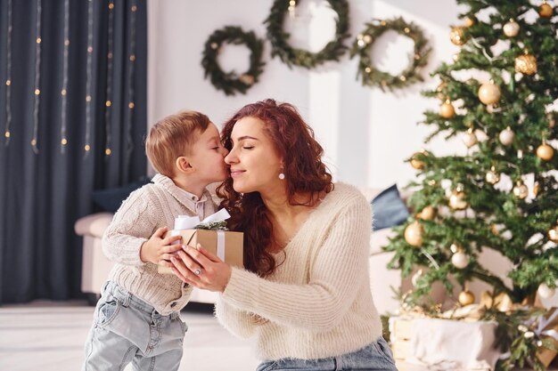 La mamma con il figlioletto è a casa decorazioni natalizie