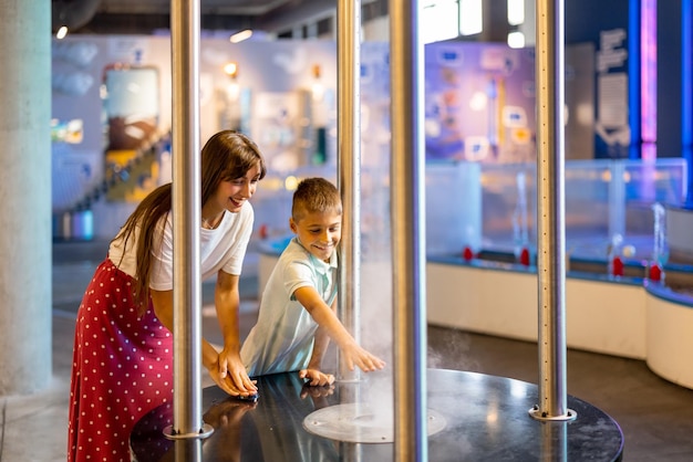 La mamma con il ragazzo visita un museo della scienza