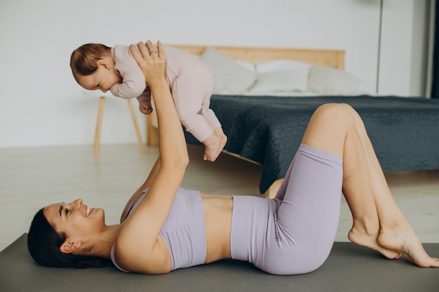 La mamma con la sua bambina pratica lo yoga a casa