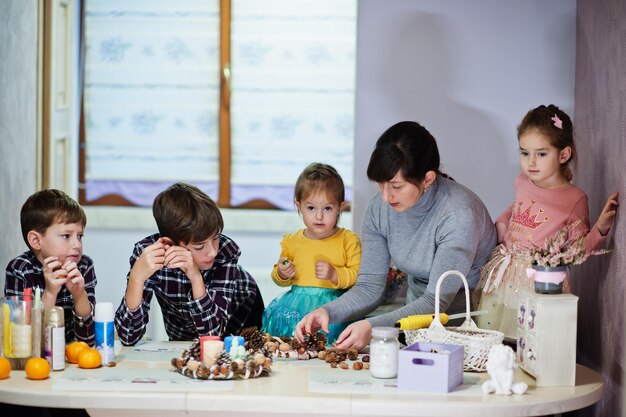 La mamma con quattro bambini fa una ghirlanda per la vigilia di Natale e crea decorazioni. Festa di Capodanno.