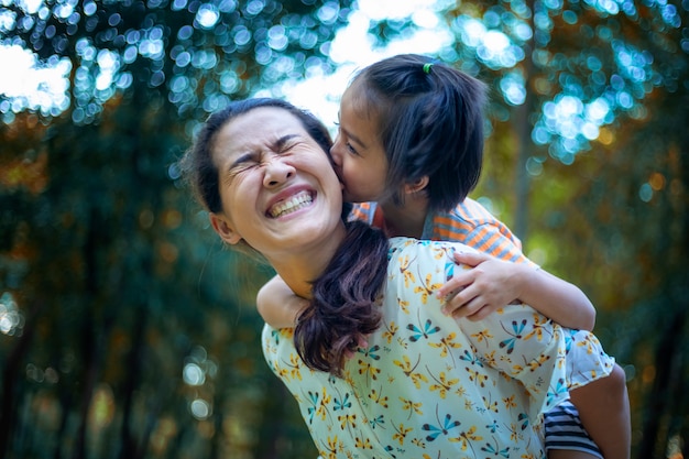 La mamma e il bambino sono felici, sorridenti, godendo l'aria calda e pura in un bellissimo giardino.