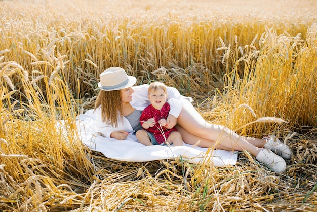 La mamma e il figlioletto sono sdraiati su una coperta a un picnic Passeggiata in famiglia nel campo