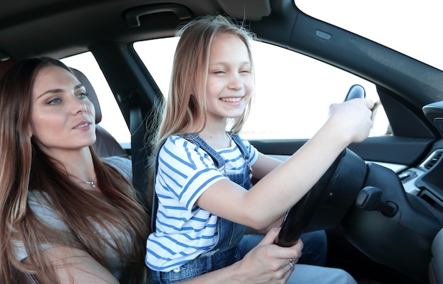 La mamma e la figlia si siedono al volante di una macchina, il concetto di genitorialità