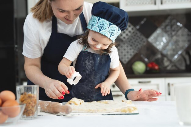 La mamma e la sua piccola figlia preparano la pasticceria in cucina