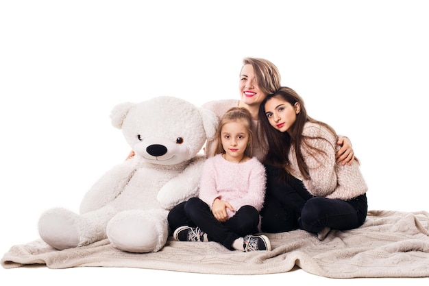 La mamma e le due figlie si siedono sulla coperta e si abbracciano
