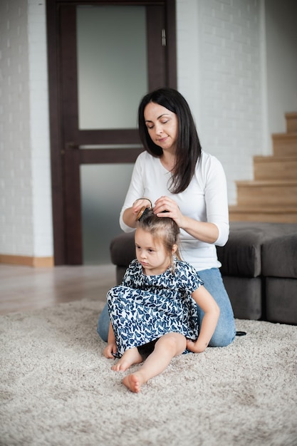 La mamma fa i capelli a sua figlia al mattino