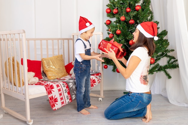 La mamma fa un regalo a un bambino per Natale