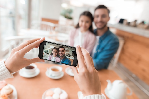 La mamma fotografa la sua famiglia sullo smartphone.