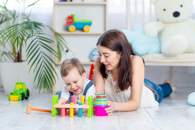 La mamma gioca con il bambino a casa nei giocattoli educativi nella stanza dei bambini Una famiglia felice e amorevole