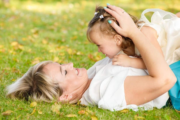 La mamma ha abbracciato la sua piccola figlia nel parco in estate con tempo soleggiato