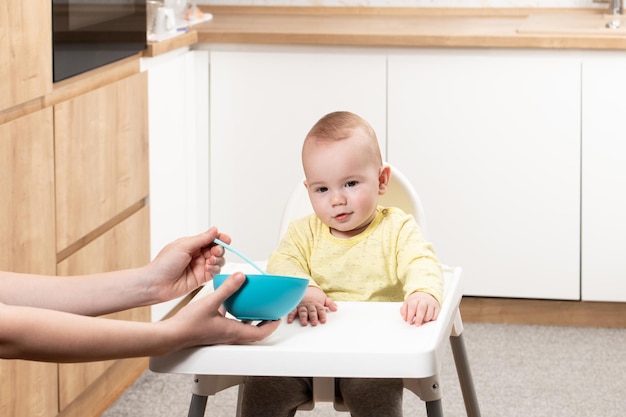 La mamma nutre il bambino con la purea di frutta a casa