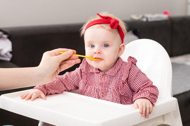 La mamma nutre il bambino con la purea di frutta a casa