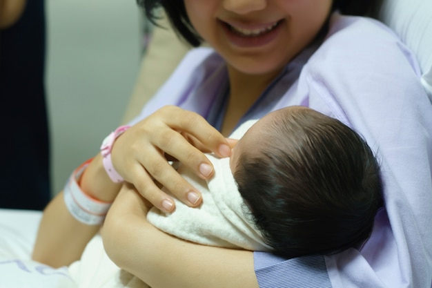 La mamma sorride felice quando vede il suo neonato in ospedale.