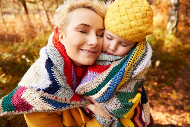 La mamma sta aiutando la ragazza a riscaldarsi