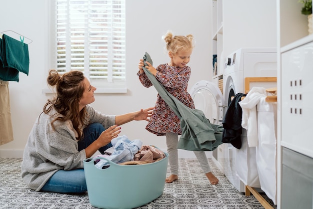 La mamma trascorre del tempo con la figlia nella lavanderia del bagno mentre fa le faccende quotidiane