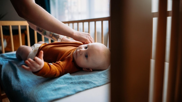 La mamma traveste un bambino piccolo con gli occhi azzurri