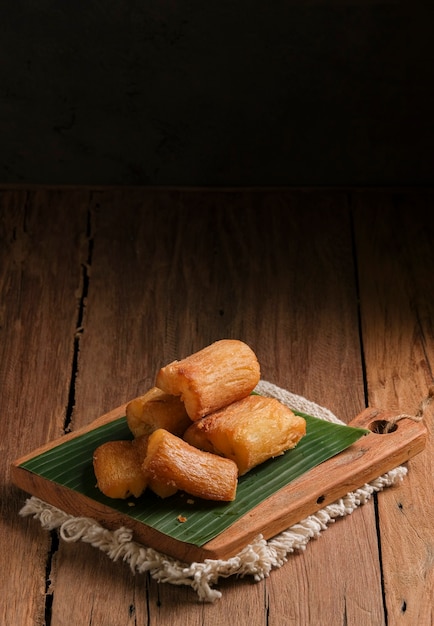 La manioca fritta viene servita su un tagliere con una base di foglie di banana. Organizzato in modo tale con un tema classico del tavolo da cucina