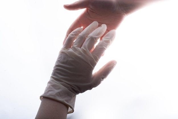 La mano con guanto protettivo in lattice sterile dà una mano