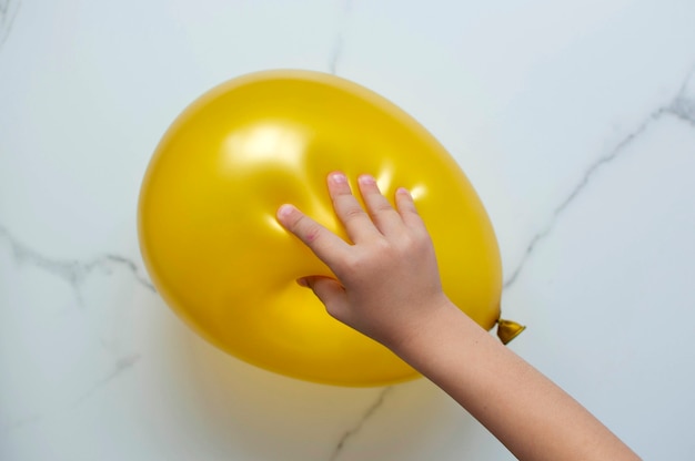La mano del bambino sta giocando a un gioco educativo tattile, cercando di far scoppiare un palloncino.