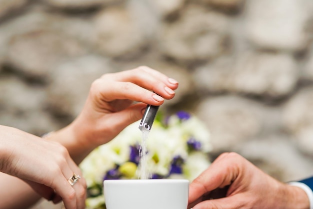 La mano del caffè versa lo zucchero