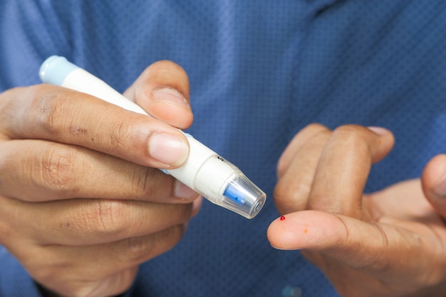 La mano del giovane misura il livello di glucosio a casa