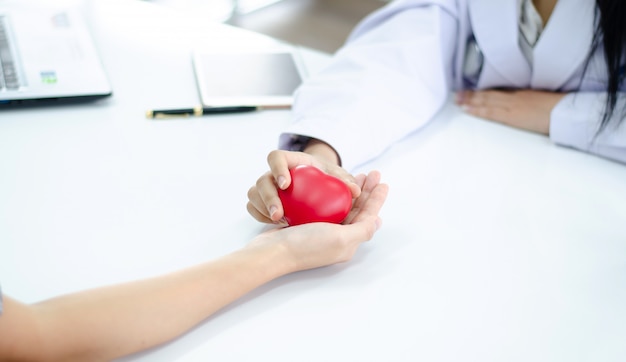 La mano del medico dà il cuore alla mano della gente