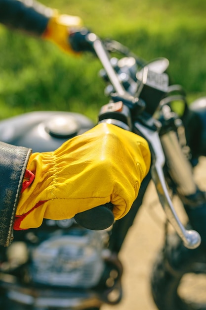 La mano del motociclista con i guanti che afferra il manubrio