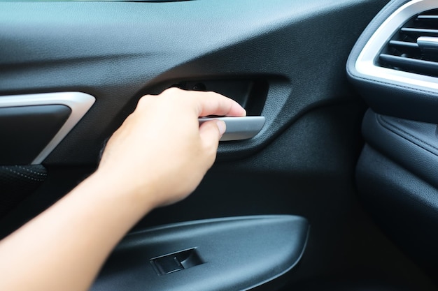 La mano del passeggero dell'auto apre la porta dall'interno