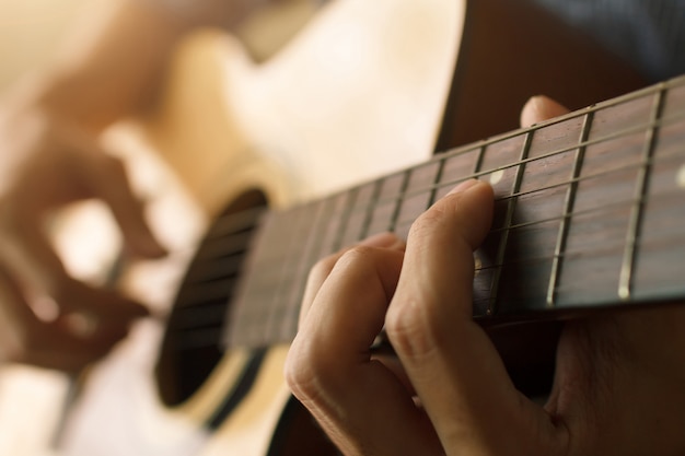 La mano dell'uomo che gioca chitarra acustica, concetto musicale