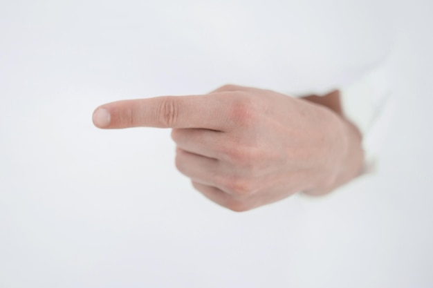 La mano dell'uomo che sfonda il muro di carta e indica la tua foto con lo spazio della copia