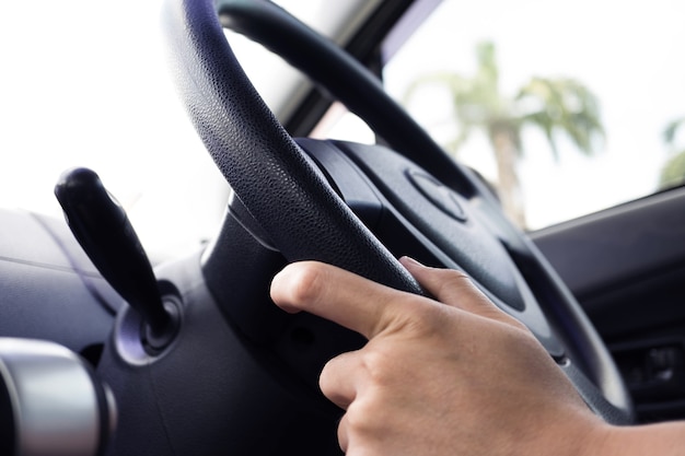 La mano dell&#39;uomo che tiene sterring spinge dentro un&#39;automobile