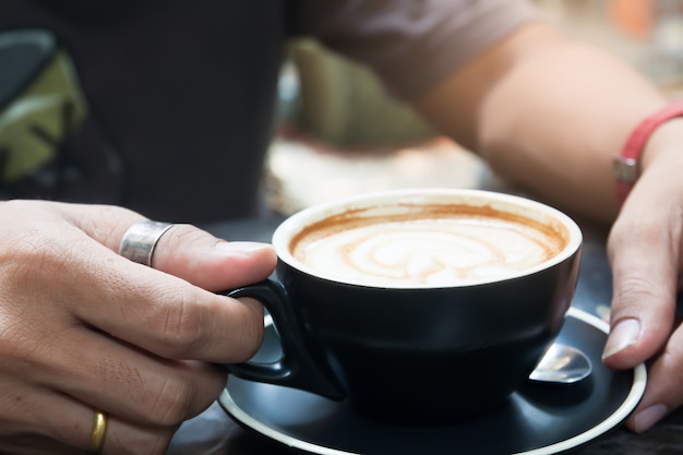 La mano dell&#39;uomo che tiene tazza di caffè