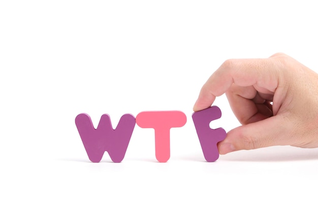 La mano dell'uomo espone l'abbreviazione wtf in lettere sullo sfondo bianco