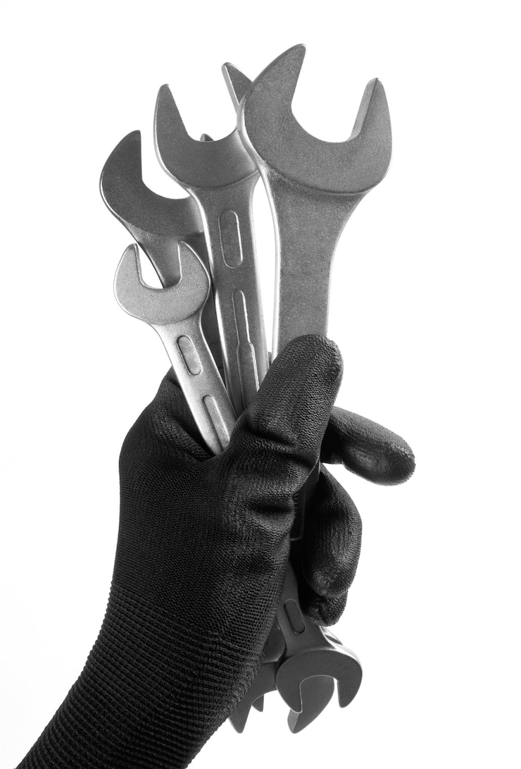 Foto la mano dell'uomo in un guanto da lavoro tiene una chiave