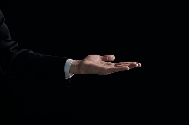 La mano dell'uomo mostra un gesto con un palmo su uno sfondo nero